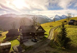 ein Haus auf einem Hügel mit Bergen im Hintergrund in der Unterkunft Drevenica Spiaci Goral in Ždiar