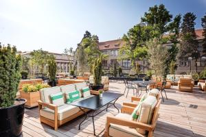 a patio with tables and chairs and trees at Dinamo Hotel Baku in Baku