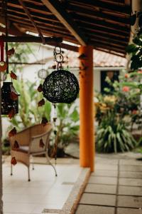 a patio with a bench and a chandelier at Pousada Nel Blu in Itaparica