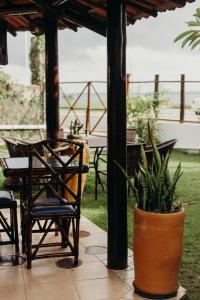 a patio with a table and chairs and a potted plant at Pousada Nel Blu in Itaparica Town