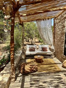 a bed on a wooden deck with a canopy at Atlantis 12, Maison d'hôtes et d'art in Essaouira