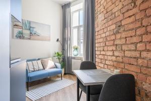 - un salon avec un canapé bleu et un mur en briques dans l'établissement Prestigious Former Library Apartment - Perfect Location, à Riga