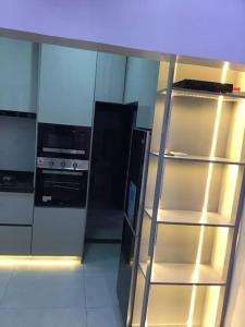 a kitchen with a stove and a refrigerator at Brandison Apartments in Rumodome