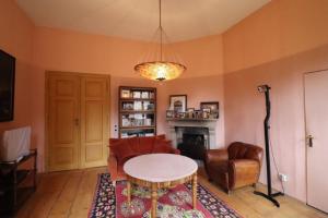 ein Wohnzimmer mit einem Tisch, Stühlen und einem Kamin in der Unterkunft Haus Tanegg in Innsbruck
