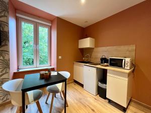 a small kitchen with a table and a microwave at LesCinqSuites/ Le Marrakech - DABNB in Limoges