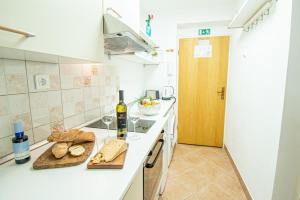 a kitchen with a counter with bread and a bottle of wine at Umag center apartment parking by Rentistra in Umag