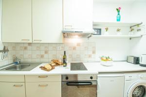 a kitchen with white cabinets and a sink and a dishwasher at Umag center apartment parking rentistra in Umag