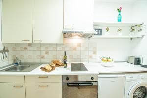 a kitchen with white cabinets and a sink and a dishwasher at Umag center apartment parking by Rentistra in Umag +11 photos