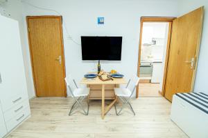 a room with a table with chairs and a television at Umag center apartment parking by Rentistra in Umag