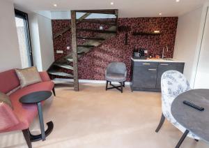 a living room with a table and chairs and a staircase at Bed & Breakfast Ons Plekje in Zwolle