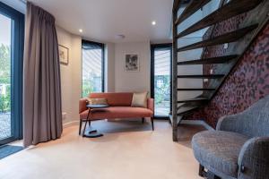 a living room with a staircase and a chair at Bed & Breakfast Ons Plekje in Zwolle