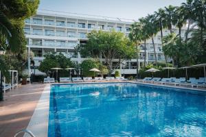 a large swimming pool with chairs and a building at THB Los Molinos - Adults Only in Ibiza Town