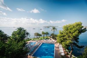 an aerial view of a resort with a swimming pool and the ocean at THB Los Molinos - Adults Only in Ibiza Town