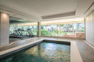an indoor swimming pool in a house with a large window at THB Los Molinos Adults Only in Ibiza Town