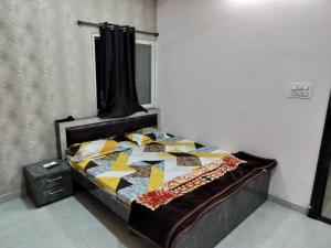 sypialnia z łóżkiem z kołdrą w obiekcie Shiv Shakti Homestay w mieście Ujjain