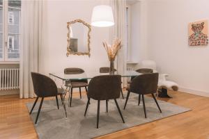 a dining room with a glass table and chairs at Tergesteo Adriatic Suite in Trieste