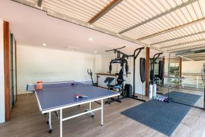 a ping pong table in a room with a gym at The Spotted Gum Northern Beaches in Warriewood
