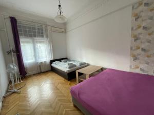 a bedroom with a bed and a table in it at White Pearl Rooms near Gozsdu in Budapest +16 photos