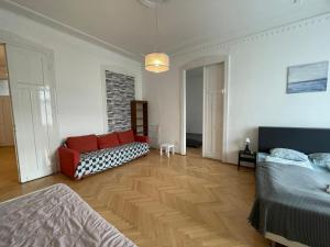a living room with a bed and a couch at White Pearl Rooms near Gozsdu in Budapest
