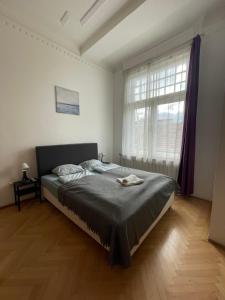 a bedroom with a bed and a large window at White Pearl Rooms in Budapest