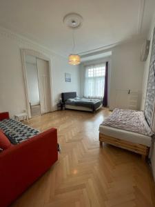 a living room with two beds and a red couch at White Pearl Rooms in Budapest