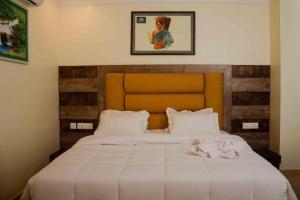 a bedroom with a large bed with white sheets at Hotel Grand Lotus Dimapur in Dimāpur