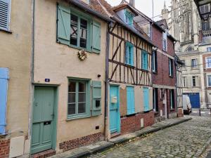 - un bâtiment ancien avec des portes et des fenêtres bleues dans une rue dans l'établissement LA PETITE BEAUVAISIENNE, à Beauvais