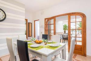 uma sala de jantar com uma mesa branca e cadeiras em Villa Mar Azul em Arenal d'en Castell