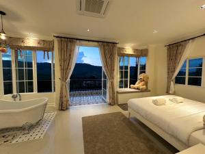 a bedroom with a tub and a teddy bear sitting on a bed at Misty English Cottage in Ban Non Na Yao