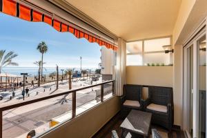 a balcony with chairs and a view of the beach at Saturno in Fuengirola