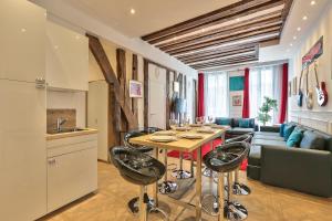a kitchen and living room with a table and chairs at 68 - The Rolling Stones Flat in Paris
