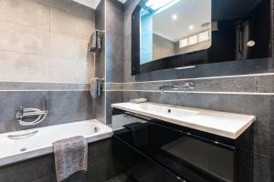 a bathroom with a sink and a tub and a mirror at Saturno in Fuengirola +16 photos