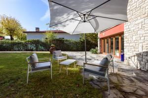 a group of chairs and an umbrella in a yard at Villa Cannas by Mmega in Forte dei Marmi
