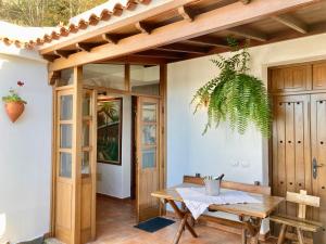 uma sala de jantar com uma mesa e um vaso de plantas em BELLA DORAMAS Casas Rurales Panchita & Millo em Moya