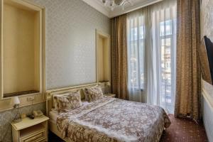 a bedroom with a bed and a large window at Vintage Art Hotel in Odesa