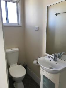 ein Badezimmer mit einem WC, einem Waschbecken und einem Spiegel in der Unterkunft Australian Hotel Winton Cabins in Winton