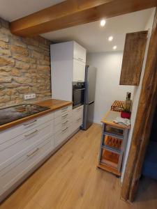eine Küche mit weißen Schränken und einer Steinmauer in der Unterkunft Sabrina's Sandsteinhaus in Flonheim
