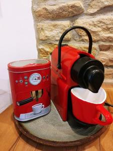 eine rote Kaffeemaschine neben einer Tasse in der Unterkunft Sabrina's Sandsteinhaus in Flonheim