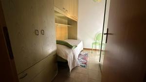 a small bedroom with a bed and a glass door at Casa Astra a Coriano-Riccione in Ospedaletto