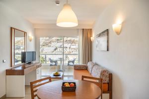 a living room with a table and a couch at Apartamentos Altair in Puerto Rico de Gran Canaria