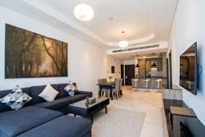 TIME Onyx Hotel Apartments في دبي: غرفة معيشة مع أريكة زرقاء وطاولة
