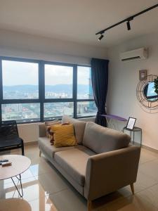 a living room with a couch and large windows at FHS Homestay @ Arte Plus Jalan Ampang T1-40-02 in Kuala Lumpur