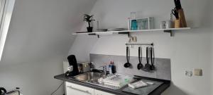a kitchen with a sink and a counter with utensils at Berg Messe DG 1Zi, K,D,B Parkplatz, W-Lan, Homeoffice in Bergisch Gladbach