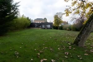 a house in a field with leaves on the grass at Villa Isaac - Luxueuse - Parking - 16p - Rêve au Mans in Le Mans