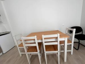 a white dining room table with two white chairs at Les Orchidées - Campagne - 2pers - Rêve au Mans in Saint-Mars-sous-Ballon