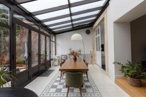 a conservatory with a table and chairs in a house at Les Bahamas - Piscine - Centre - 16p - Rêve au Mans in Le Mans