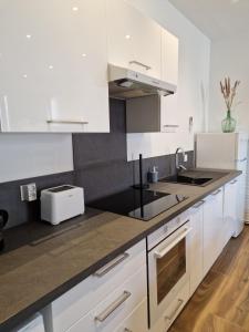 a kitchen with white cabinets and a sink at Le Saphir - Centre - Confort - 6p - Rêve au Mans in Le Mans