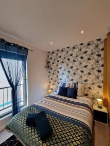 a bedroom with a large bed with a stone wall at Le Saphir - Centre - Confort - 6p - Rêve au Mans in Coulaines
