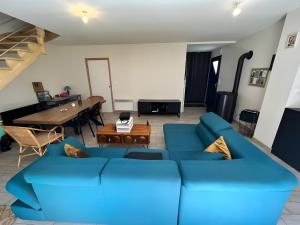 un soggiorno con divano blu e tavolo di Le Cube - PMR - wifi - 4pers - Circuit a Parigné-lʼÉvêque