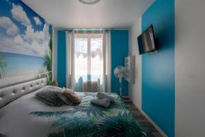 a bedroom with a bed with blue walls and a window at Le Paradis Manceau - Centre - 6 pers - Rêve au Mans in Le Mans